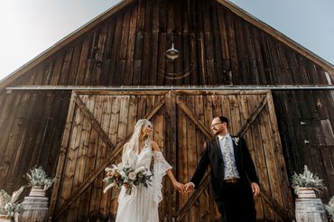 Couple hold hands at Tin Roof Barn after their wedding ceremony