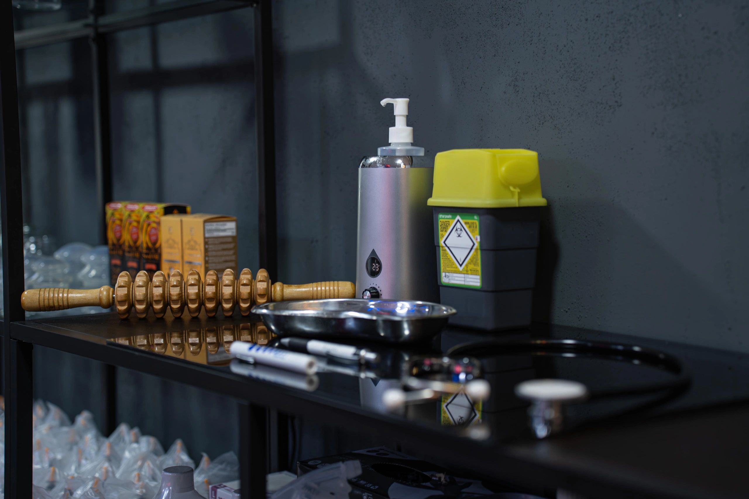 Medical equipment and supplies neatly arranged on a black shelf.