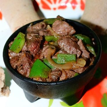Spicy beef stir-fry with green peppers and onions served with injera bread.