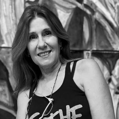 Mujer sonriente con camiseta negra sin mangas.