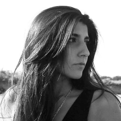 Mujer de perfil con cabello largo y oscuro, en blanco y negro.