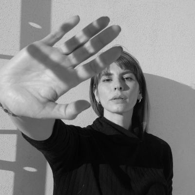 Mujer con mano levantada en fotografía en blanco y negro.