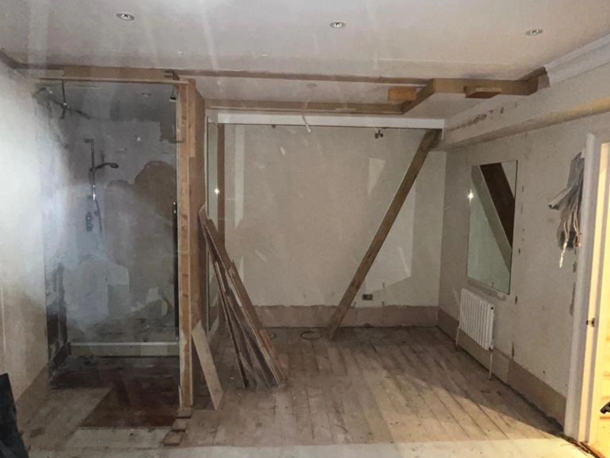 Empty room under renovation with exposed wooden beams and planks.