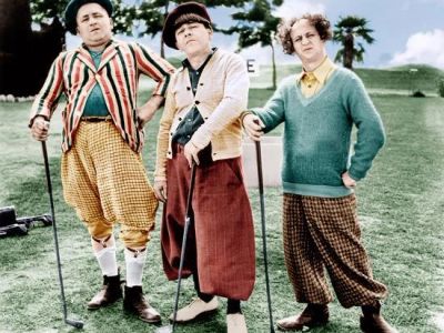 Three men in vintage golf attire posing with golf clubs.