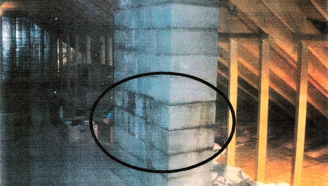 Chimney structure in attic area of a house, showing black stains leaking through the chimney structu