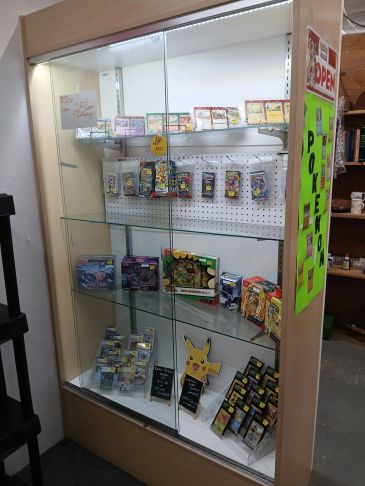 Display case with various Pokémon cards and merchandise.