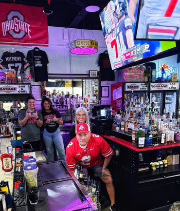 Group of Ohio State fans at a bar with football game on TV.