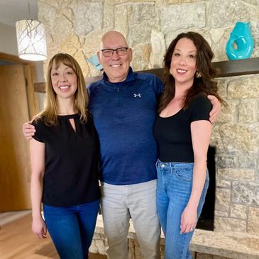 Three people posing and smiling indoors.