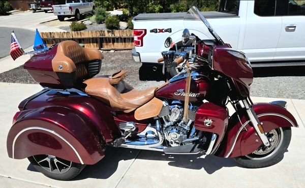 Maroon Indian motorcycle with three wheels and tan seats.