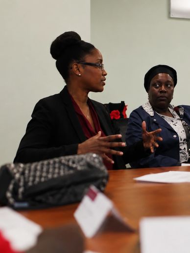 Two women engaged in a serious discussion at a meeting table.