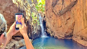 Guest taking a photo of a waterfall at El Questro Gorge
