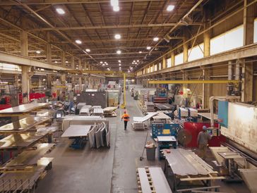 A spacious industrial factory with machinery and workers.