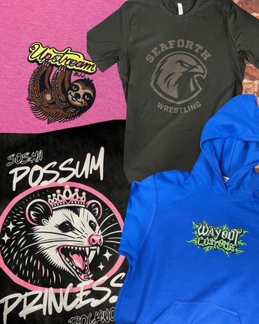 Four colorful shirts with unique animal and text designs.