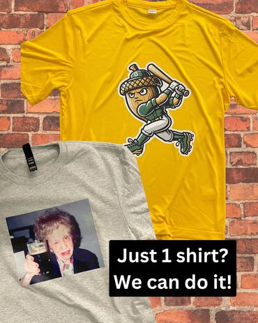 Two graphic t-shirts on a brick background with motivational text.