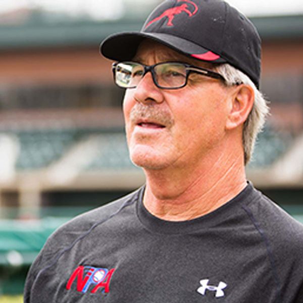 Older man in sports attire and cap looking thoughtful.