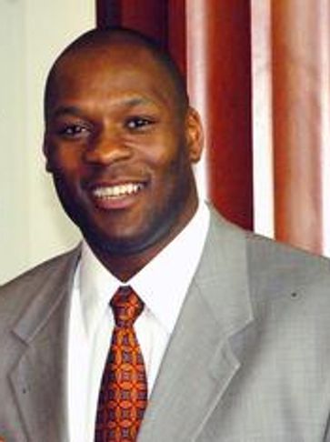 Man in gray suit smiling.