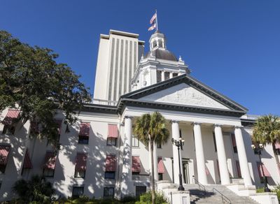 front view of a white building with the USA flag