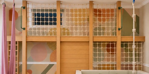Custom indoor play space with climbing nets, foam pit, aerial silk swing, and elevated clubhouse des