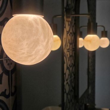 Moon-shaped bathroom wall lights beside backlit his and hers mirrors in Long Gully
