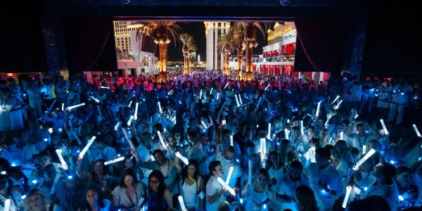 Crowd with glowing sticks at a night event.