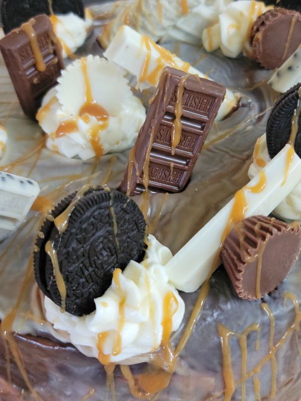 CHOCOLATE CAKE COVERED WITH WHITE AND CHOCOLATE GANACHE, CREAMCHEESE FILLING, TOPPED WITH OREOS,  HE