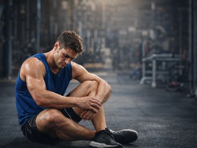 Tired man resting on the gym floor after a workout.