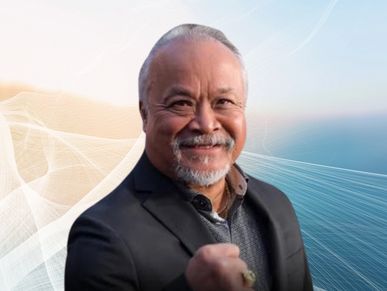 Smiling man in a suit showing a fist with a confident expression.