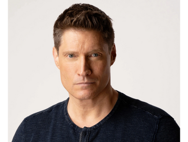 Portrait of a serious man with blue eyes and short brown hair.