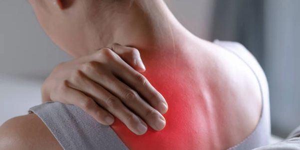 Person holding sore, red shoulder area indicating pain.