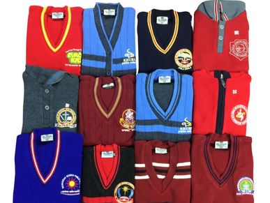 Collection of folded school sweaters with various colors and logos.