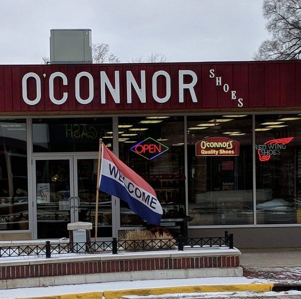 O'Connor Shoes store exterior with welcome flag and neon signs.