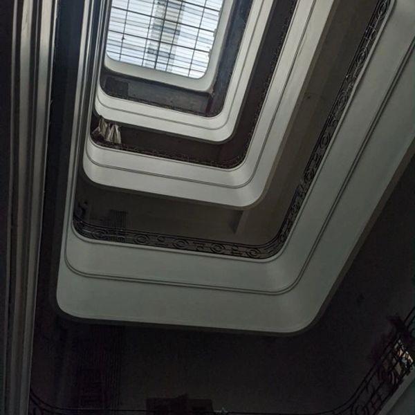 Looking up through a spiral staircase in a building.