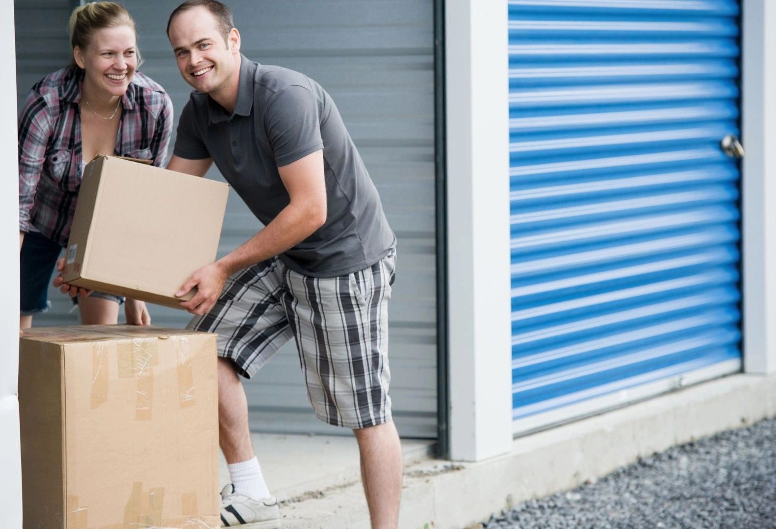 Two people moving boxes into their storage unit at Green Diamond, Silt CO storage facility.
