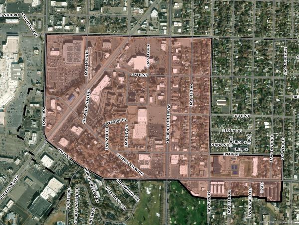 Aerial view of a city section with streets and buildings marked and shaded in pink.