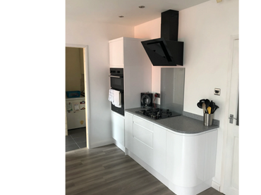 Curved gloss white units with Minerva worktops with matching curve