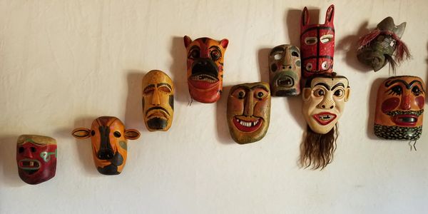 wooden mask collection on a wall display