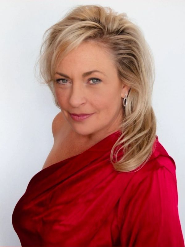 Woman with blonde hair in a red dress smiling.