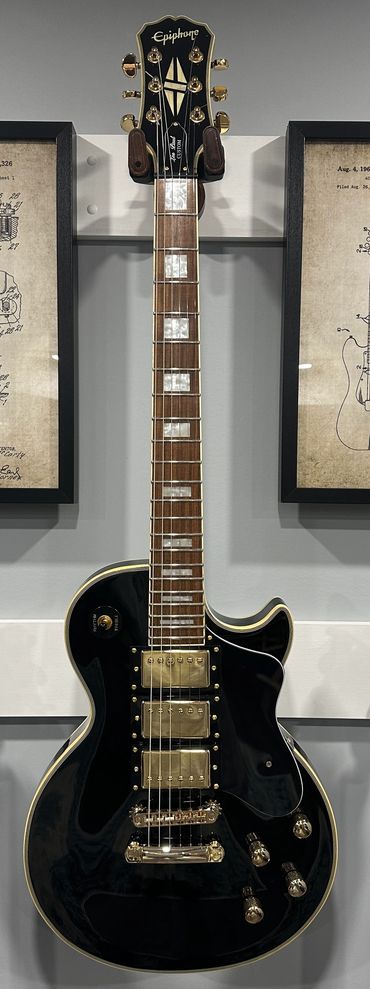 Black Epiphone electric guitar with gold hardware and pearl inlays.