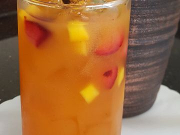 A refreshing iced fruit drink garnished with lemon and mint.