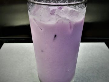 A glass of iced purple taro milk tea.