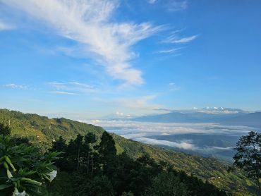 Scenic mountain landscape with clouds and clear blue sky.