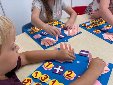 Children using felt hand cutouts and numbers for a math activity.