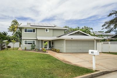 Modern two-story house with solar panels and a well-kept lawn.