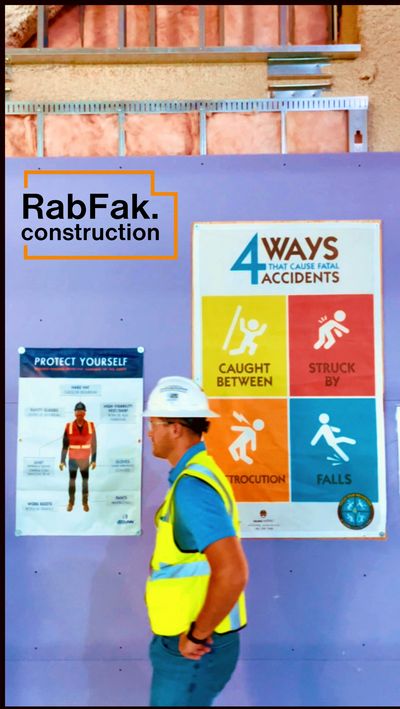 A construction worker with safety gear: hard hat, safety glasses, high visibility vest, work boots