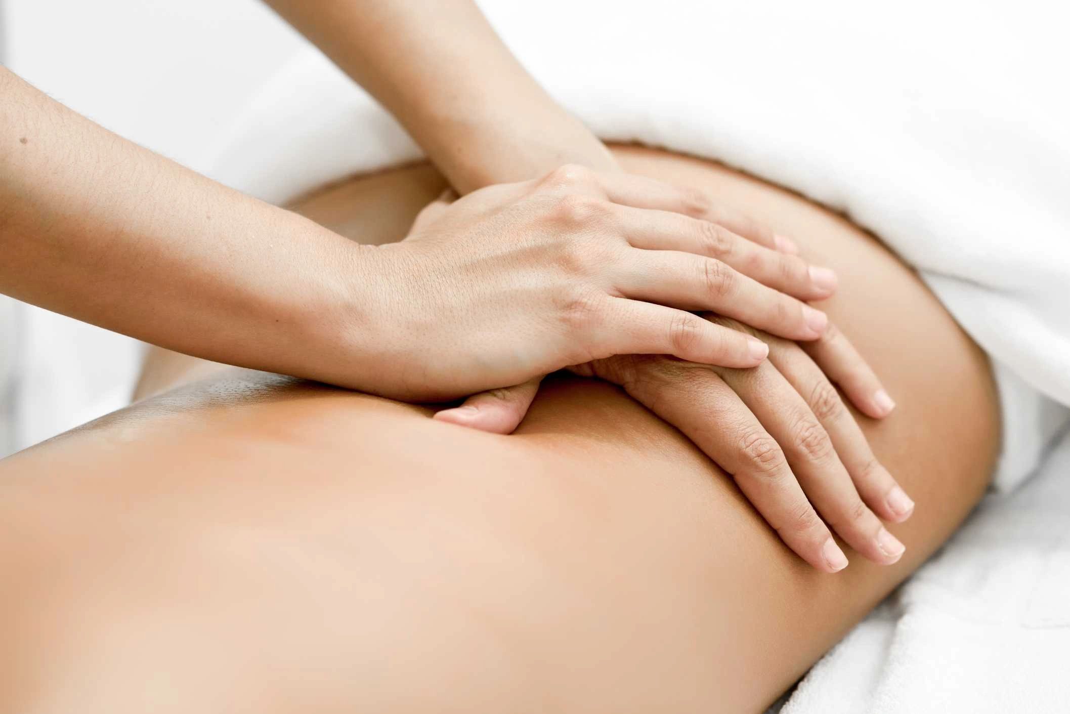 Hands are shown giving a relaxing back massage with oil
