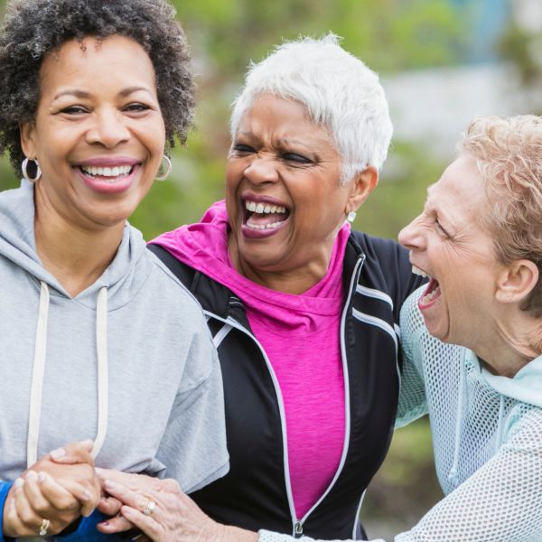 Three elderly women laughing and enjoying each other's company.