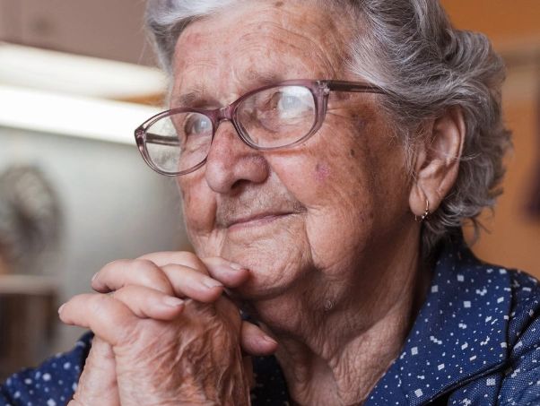 Elderly woman in her kitchen crossing her hands