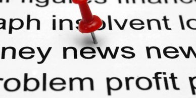 A red pushpin on the word "news" in a printed text.