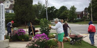 Volunteers are working on the garden near the Peace Pole.
