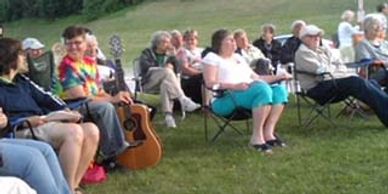 A group of people are sitting at the Park.